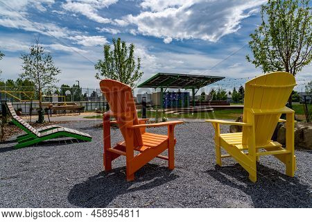 Calgary Alberta Canada, July 09 2022:  Solar Rooftop Amphitheater Between Two Painted Wooden Adirond