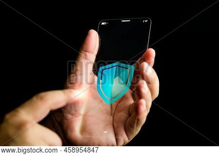 Shield Icon On The Thin Screen Of Futuristic Transparent Glass Smartphone In Hand. Data Or Network P