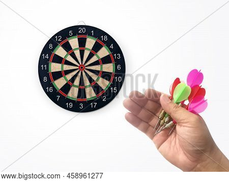 Human Hand Is Throwing The Darts Target To The Darts Board. A Man's Hand Throws A Dart At The Target