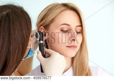 Otolaryngologist Doctor Examining Patients Ear With Otoscope In Clinic. Diagnosis Of Otitis Media Co