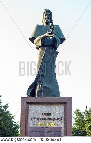 Dushanbe, Tajikistan - July 20, 2022: Statue Of Persian Poet Ferdowsi In The Park Against The Blue S