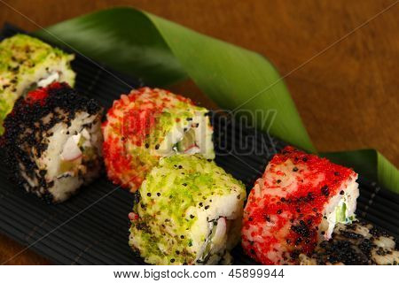 Velsmagende Maki sushi - Roll på måtten på brune baggrund