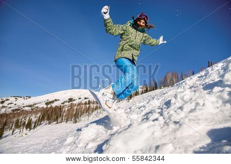 Snowboarder jumping through air with deep blue sky in background