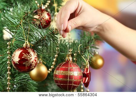 Decorating Christmas tree on bright background