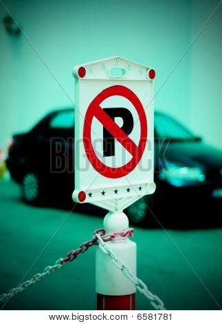 Nenhum sinal de estacionamento com o carro no fundo