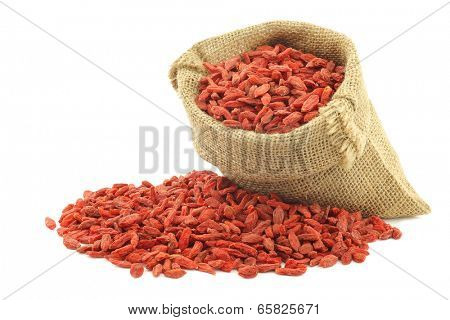 dried goji berries (Lycium Barbarum - Wolfberry) in a burlap bag on white background