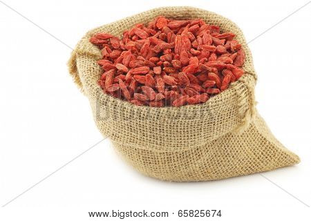 dried goji berries (Lycium Barbarum - Wolfberry) in a burlap bag on white background