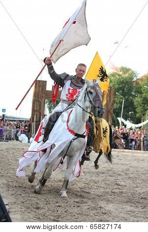 Riga, Latvia - August 21: Member Of The Devils Horsemen Stunt Team Riding Horse And Holding Flag Dur