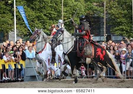 Riga, Latvia - August 21: Two Members Of The Devils Horsemen Stunt Team Fighting With Swords During