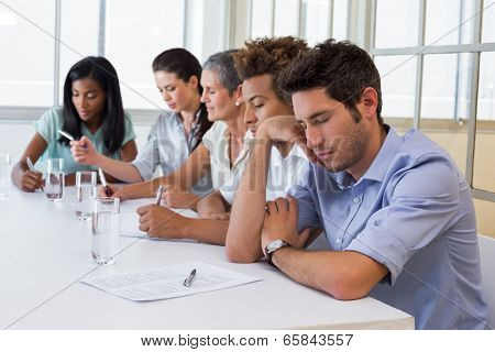 Casual businessman falling asleep during meeting in the office