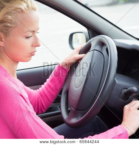 Female car driver starting the engine.