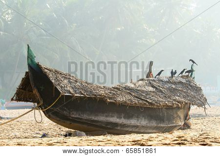 Fishing Boat On The Beach Against Jungle Background