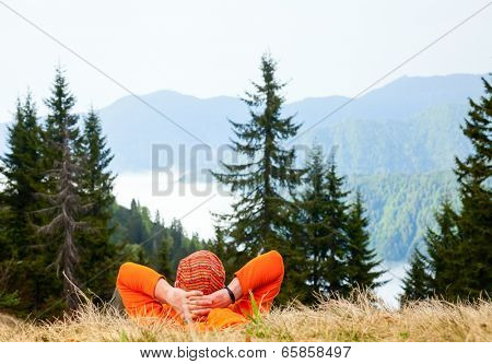 Hiker resting at viewpoint overlooking scenic mountains