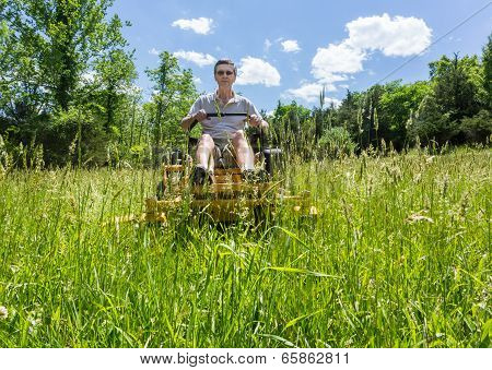 Senior Man On Zero Turn Lawnmower In Meadow