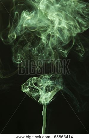 Green colored smoke on a black background.