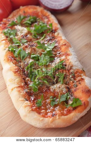 Plain homemade italian pizza with tomato sauce and herbs