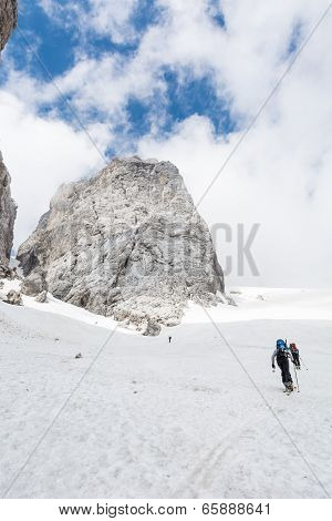 Skiiers Ascending Mountain Slope