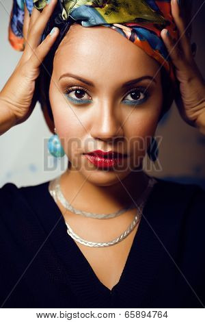 beauty bright african woman with creative make up, shawl on head like cubian woman