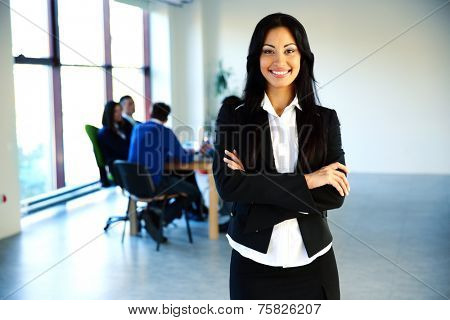 Happy businesswoman standing in front of a business meeting