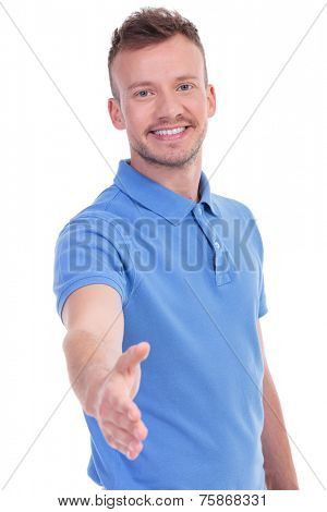 picture of a young casual man offering a friendly handshake while smiling for the camera. isolated on a white background