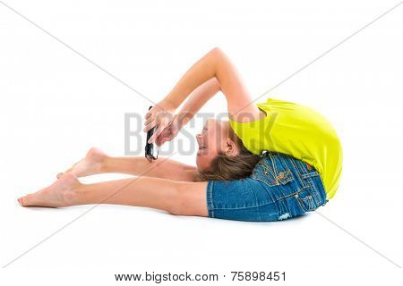 Flexible contortionist kid girl playing with tablet pc on white background