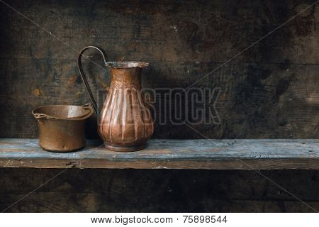 Copper jug and bowl on wood shelf
