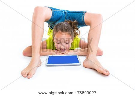 Flexible contortionist kid girl playing with tablet pc on white background