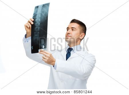 healthcare, rontgen, people and medicine concept - male doctor in white coat looking at x-ray