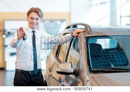 Sales man holds keys from a new car