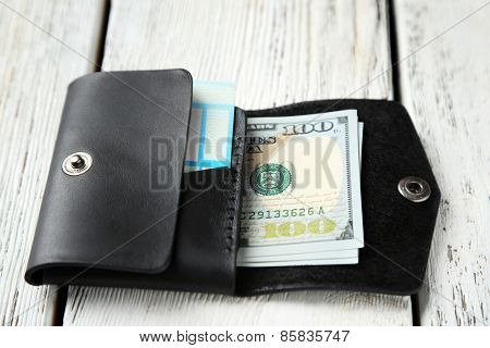 Hand made leather man wallet with money on white wooden background