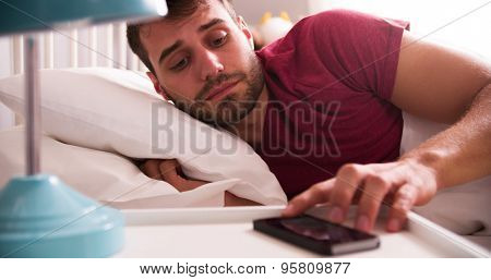 Man In Bed Woken By Alarm On Mobile Phone