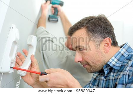 Man repairing an intercom phone