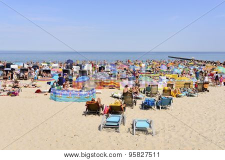 USTKA - JULY 04: Tourists enjoy the sunny weather and relaxing on the Baltic sea beach on 4 July 2015 in Ustka, Poland.