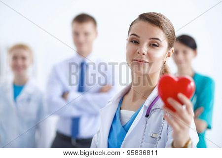 Female doctor with stethoscope holding heart .