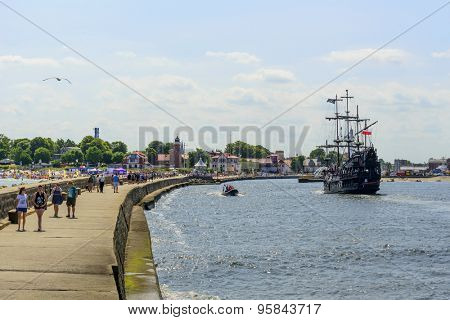 USTKA - JULY 07: Tourists enjoy the sunny weather and walking on the harbor breakwater on 7 July 2015 in Ustka, Poland.