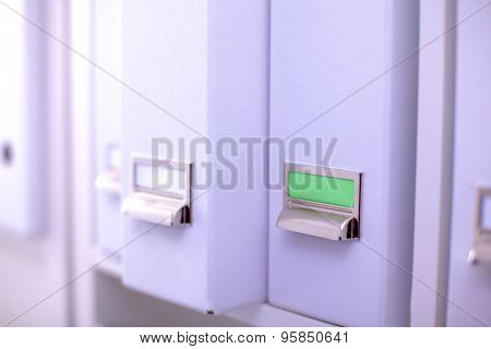 File folders, standing on  shelves in the background