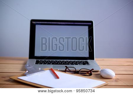 Laptop stands on a wooden table