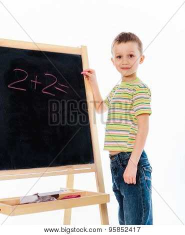 Preschooler child standing nearby chalkboard
