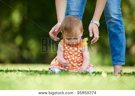 happy young baby child sittng on grass on beautiful summer day in park