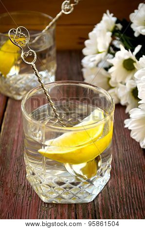 Lemonade with fresh lemon on wooden background