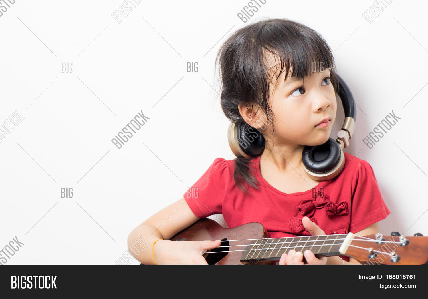Download high-quality Japanese girl playing guitar wearing headphone. image...