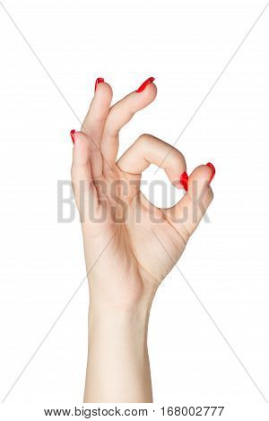Woman hand in ok sign with manicure and red nails on a white isolated background