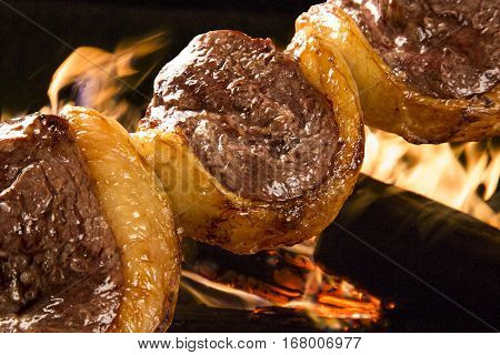 Picanha traditional Brazilian barbecue. Background with fire