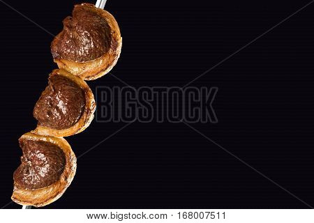 Picanha traditional Brazilian barbecue on black background.
