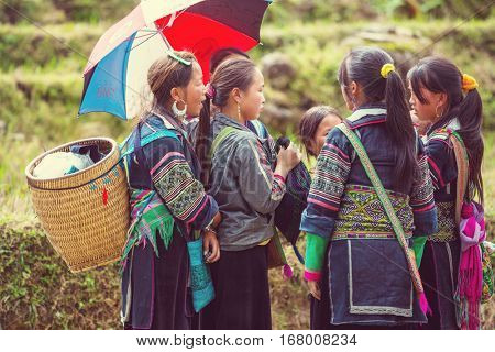 SAPA, VIETNAM - OCTOBER 29, 2012: Hmong women sell souvenirs in Sapa. The Hmongs are known for their colorful clothes and silver jewelry. Hmong women have various clothes colours and style