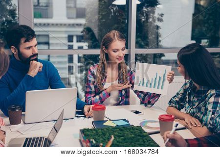 Young woman explaining diagrama of financial growh on meeting sitting at desktop