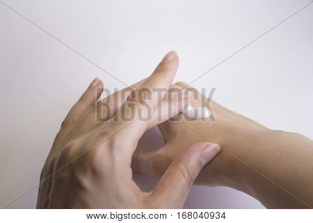Hands of caucasian woman selfmassage with cream