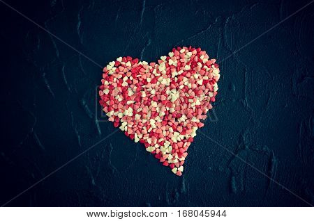 Big heart from little colorful hearts on dark stone background. Empty space for text. Valentine's Day theme. Romantic love Valentines concept.