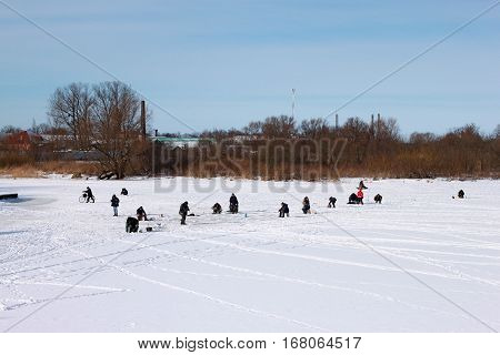 The inhabitants of the russian provinces are fishing on the ice of a small frozen river at winter. Polessk (Labiau) Kaliningrad region Russia.