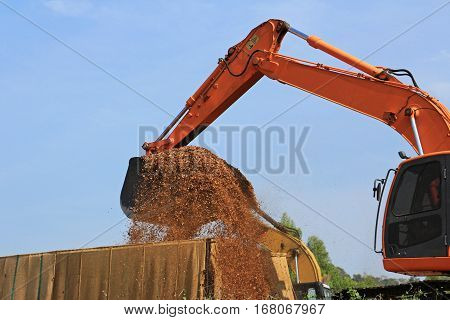 Backhoe Loading Wood Chips into a Truck